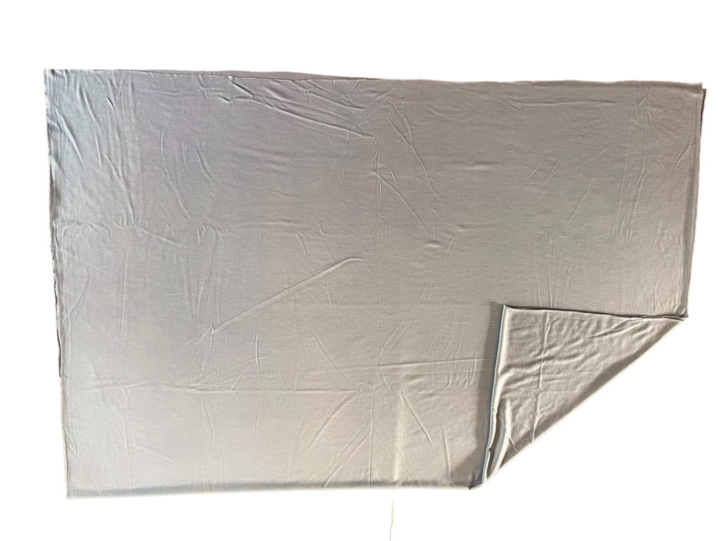 Grey merino jersey sheet laid flat on a black background with one corner folded back to show the knit