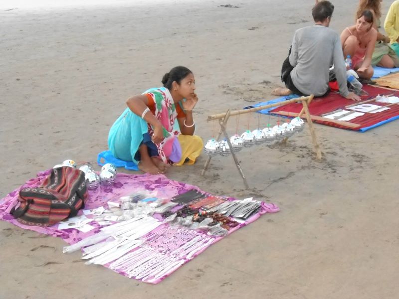 Indian girl sitting on ground with back lengthened perfectly, next to white people showing rounded backs, not educated in ancestral movement.